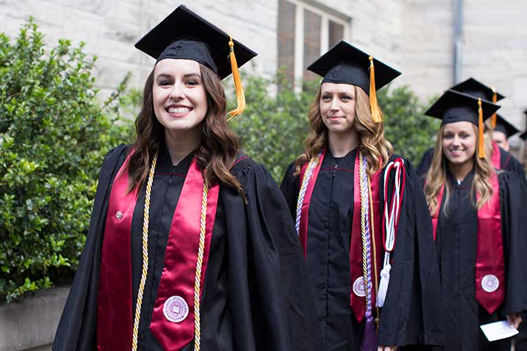 Graduates walking in caps and gowns