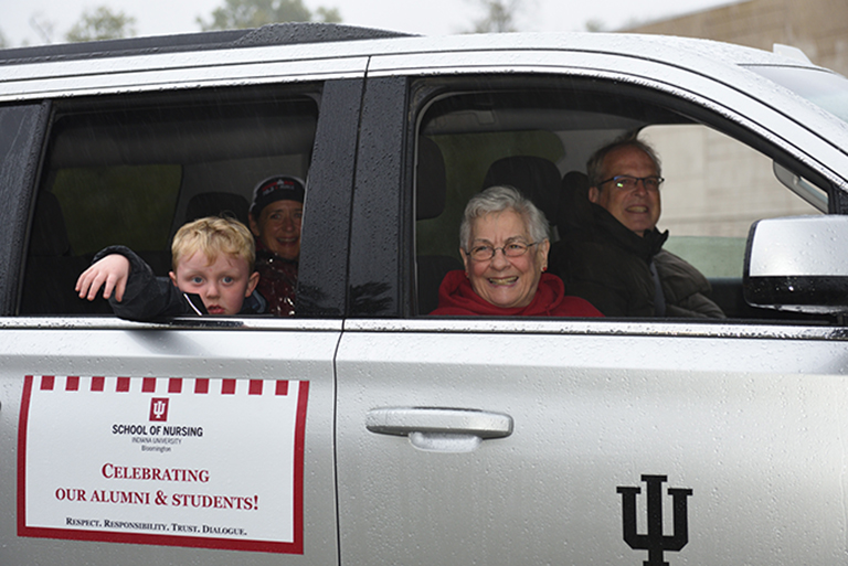 People in a car participating in homecoming parade